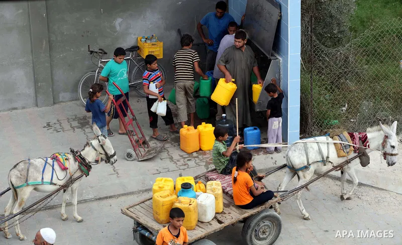 Palestinians fill their bottles a potable water at a water purification station, in Deir al-Balah central Gaza Strip, on July 26. 2012. Palestinians suffer from the severe lack of potable water during the holy fasting mo...