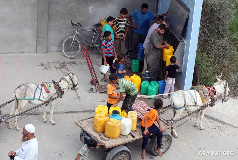 Palestinians fill their bottles a potable water at a water purification station, in Deir al-Balah central Gaza Strip, on July 26. 2012. Palestinians suffer from the severe lack of potable water during the holy fasting mo...