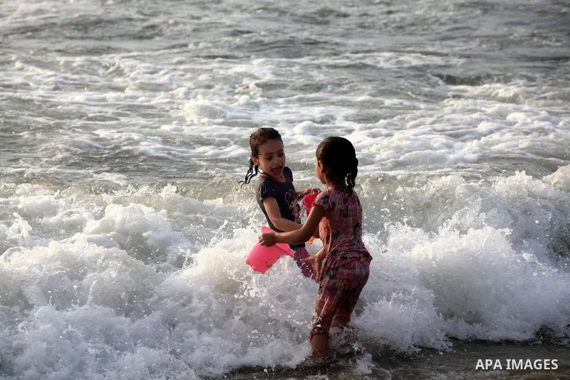 Palestinian children enjoy swimming at Gaza beach during the fasting holy month of Ramadan, in Gaza city on 26 July 2012. Photo by Majdi Fathi