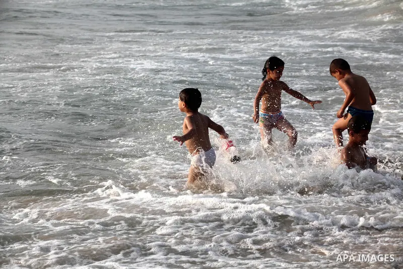 Palestinian children enjoy swimming at Gaza beach during the fasting holy month of Ramadan, in Gaza city on 26 July 2012. Photo by Majdi Fathi