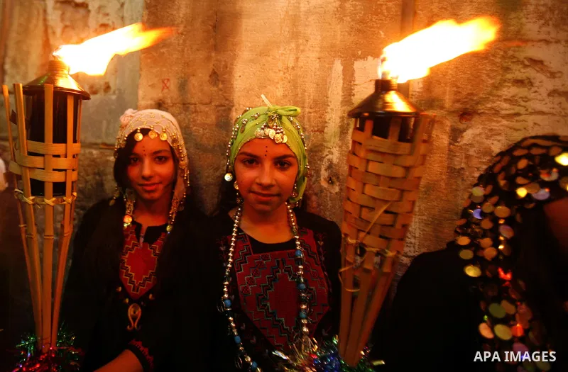 Palestinian girls hold torches in Jerusalem's Old City during celebrations to mark the breaking of the fast on the seventh day of the holy month of Ramadan, on July 26, 2012. Photo by Mahfouz Abu Turk