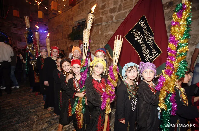 Palestinian girls hold torches in Jerusalem's Old City during celebrations to mark the breaking of the fast on the seventh day of the holy month of Ramadan, on July 26, 2012. Photo by Mahfouz Abu Turk