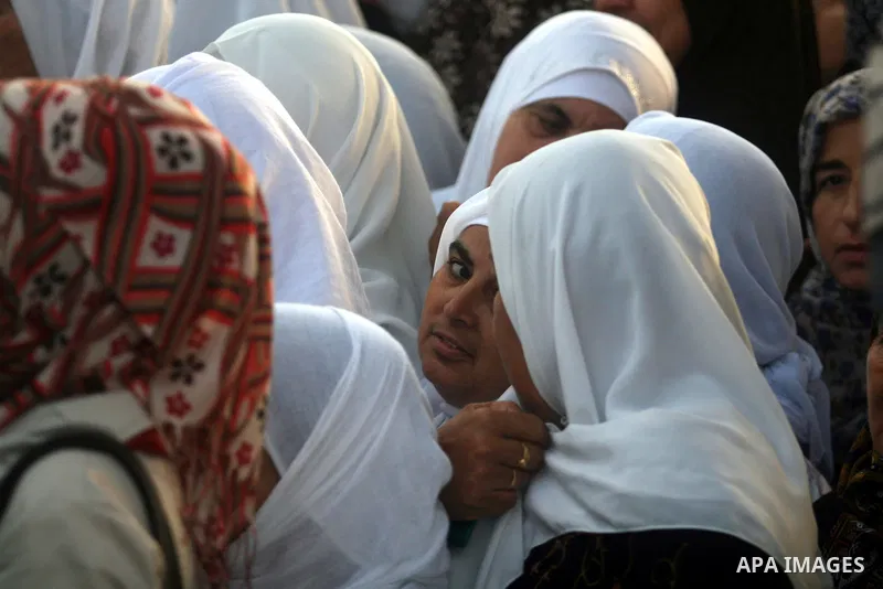 Palestinian women wait to show their identity cards to Israeli security officers at Qalandiya checkpoint outside the West Bank city of Ramallah July 27, 2012, as they make their way to Jerusalem on the second Friday of t...