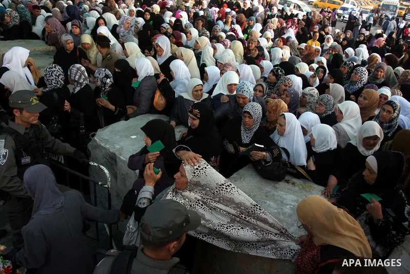 Palestinian women wait to show their identity cards to Israeli security officers at Qalandiya checkpoint outside the West Bank city of Ramallah July 27, 2012, as they make their way to Jerusalem on the second Friday of t...