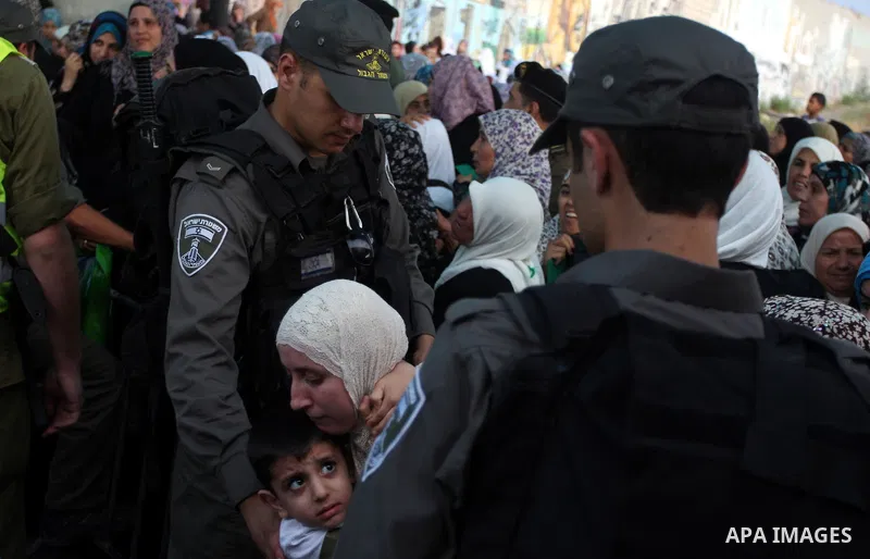 Israeli border policemen check the ID cards of Palestinian women at Qalandiya checkpoint outside the West Bank city of Ramallah July 27, 2012, as they make their way to Jerusalem on the second Friday of the holy month of...