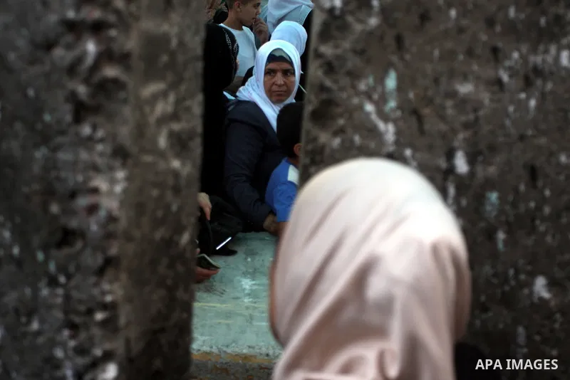 Palestinian women wait to show their identity cards to Israeli security officers at Qalandiya checkpoint outside the West Bank city of Ramallah July 27, 2012, as they make their way to Jerusalem on the second Friday of t...