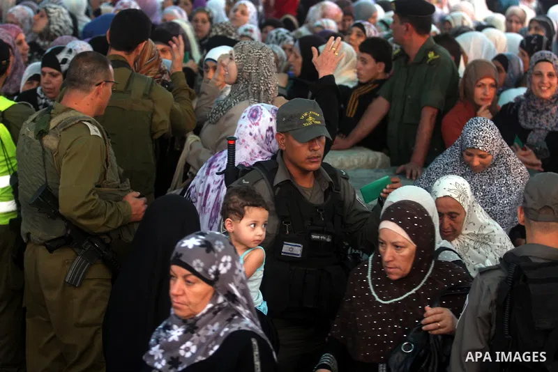 Israeli border policemen check the ID cards of Palestinian women at Qalandiya checkpoint outside the West Bank city of Ramallah July 27, 2012, as they make their way to Jerusalem on the second Friday of the holy month of...