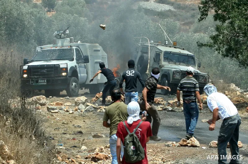 Palestinian protesters throw stones towards Israeli soldiers during clashes following a demonstrator against the expropriation of Palestinian land by Israel in the village of Kafr Qaddum, near the West Bank city of Nablu...