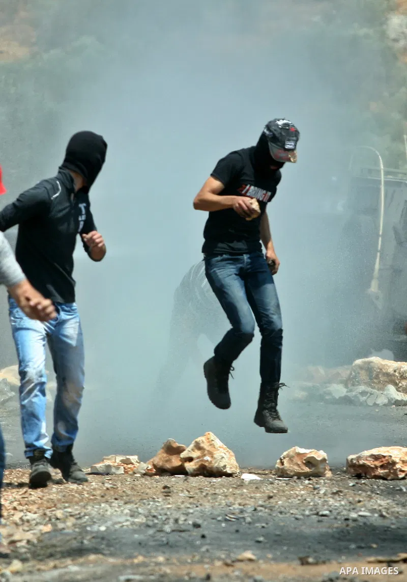 Palestinian protesters run for cover from tear gas fired by Israeli soldiers during a demonstration against the expropriation of Palestinian land by Israel in the village of Kafr Qaddum, near the West Bank city of Nablus...