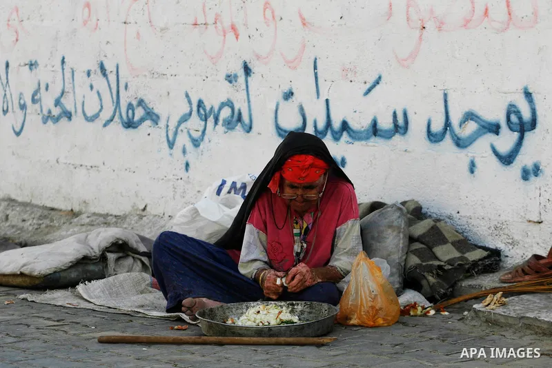 A Palestinian old woman makes food in front of her home during fasting month of Ramdan in Rafah refugee camp southern Gaza strip, on July 27, 2012. Muslims around the world abstain from eating, drinking and conducting se...