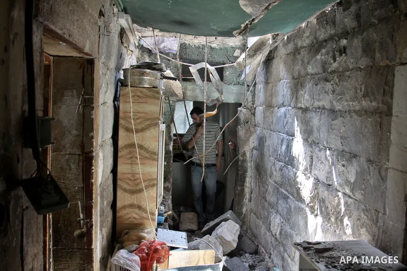 A Palestinian man inspects damage in house for member Islamic Jihad, Abdullah Al Kharouf in the West Bank city of Nablus on 28 July 2012. Photo by Nedal Eshtayah