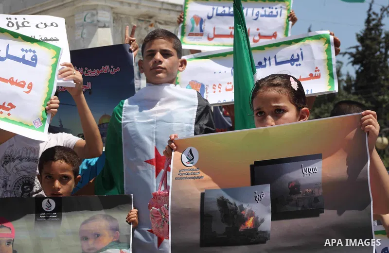 Palestinian children hold a Syrian revolution flag during a protest against Syria's President Bashar al-Assad and support of Syrian Children at the Al joundi Al Majhoul in Gaza City on July 28, 2012. Photo by Ashraf Amra