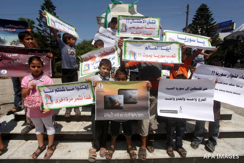 Palestinian children hold a Syrian revolution flag during a protest against Syria's President Bashar al-Assad and support of Syrian Children at the Al joundi Al Majhoul in Gaza City on July 28, 2012. Photo by Ashraf Amra