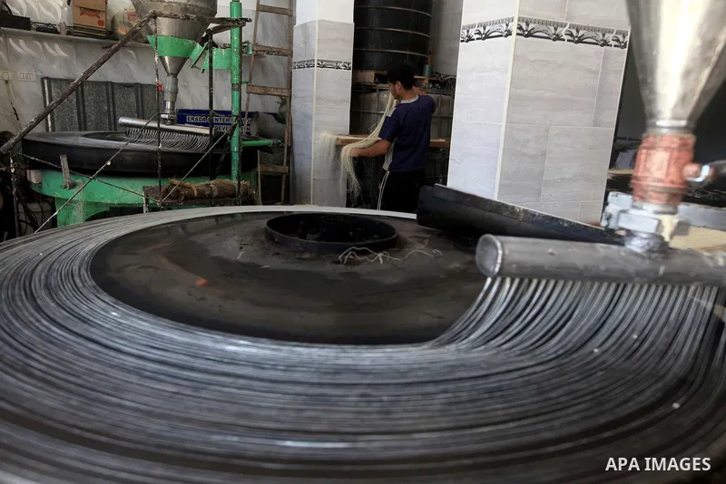 A Palestinian youth makes Konafa in Gaza city on 28 July 2012. Palestinians gets ready for break their fast "Eftar" after long hours of fasting. Bakers make Konafa and traditional pastry known as ''Qatayef'' which is con...