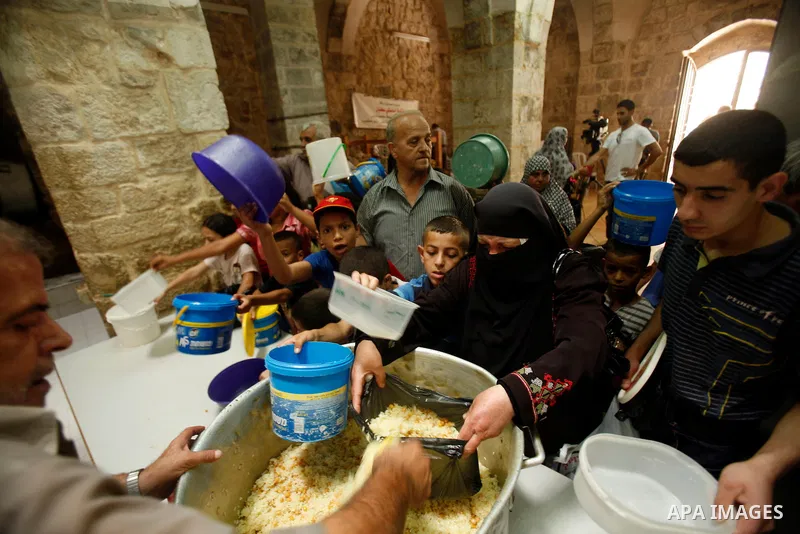 Palestinian volunteers deliver food for indigent Muslims during the fasting month of Ramadan in Jerusalem on July 28, 2012. During Ramadan eating, drinking, sex and smoking is banned and restaurants are forbidden to serv...
