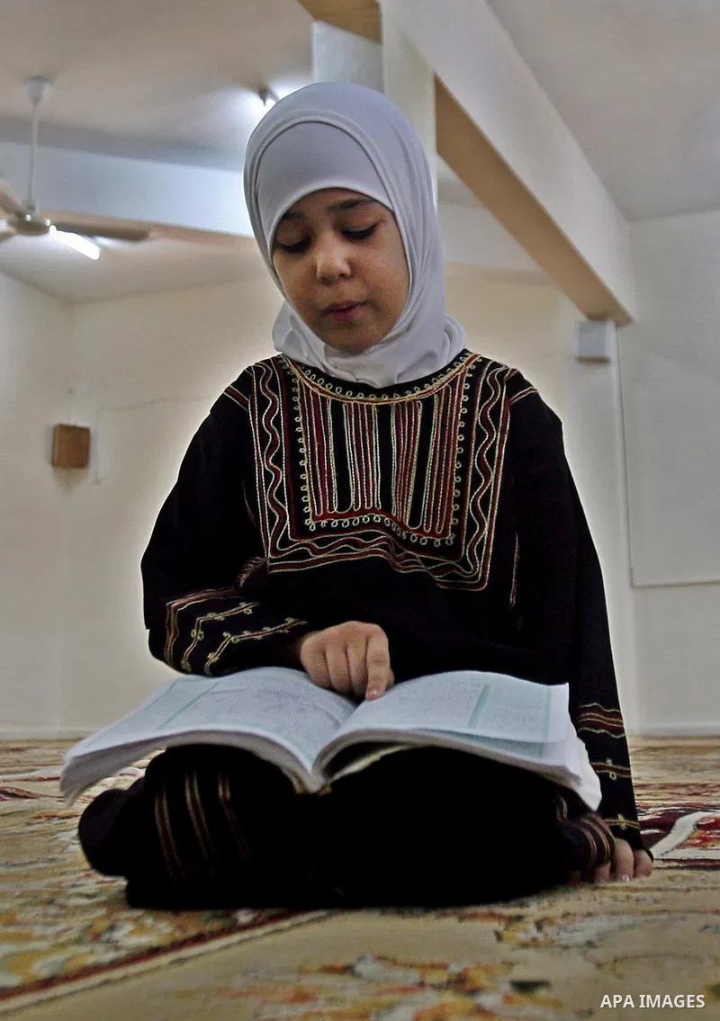 A Palestinian girl reads the holy Qur'an at mosque in the West bank city of Nablus, on 29 July 2012. Muslims around the world refrain from eating, drinking and sexual intercourse from dawn till dusk during Ramadan, the h...
