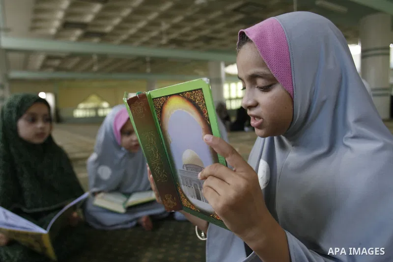 Palestinian girls read the holy Qur'an at mosque in Rafah in southern Gaza strip, on 29 July 2012. Muslims around the world refrain from eating, drinking and sexual intercourse from dawn till dusk during Ramadan, the hol...