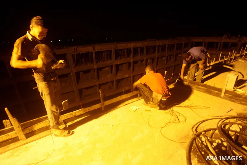 Palestinian construction workers work at night in Deir al-Balah in central Gaza Strip on 29 July 2012. Palestinian construction workers work during the night in the month of Ramadan because of the high temperatures they...