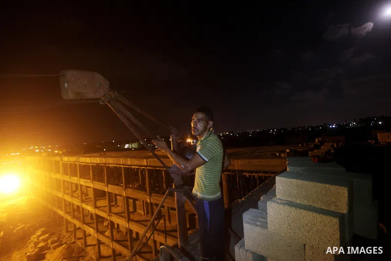 Palestinian construction workers work at night in Deir al-Balah in central Gaza Strip on 29 July 2012. Palestinian construction workers work during the night in the month of Ramadan because of the high temperatures they...