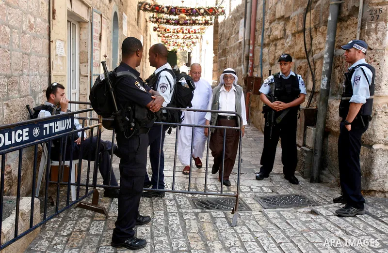 Israeli policemen stop Palestinians walk pass of Bab Hutta road, in Jerusalem old city, on 29 July 2012. Photo by Mahfouz Abu Turk