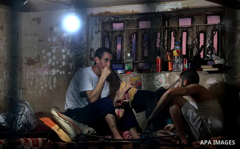 Palestinian inmates sit inside their cell during the holy month of Ramadan at prison controlled by the Hamas police in Gaza city on 29 July 2012. Hamas police released more than 150 criminal inmates before the fasting mo...