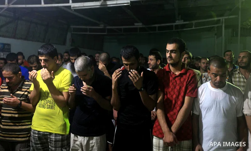 Palestinian inmates participate a prayer during the holy month of Ramadan at prison controlled by the Hamas police in Gaza city on 29 July 2012. Hamas police released more than 150 criminal inmates before the fasting mon...