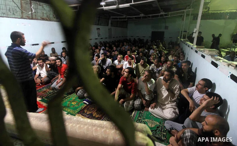 Palestinian inmates participate a prayer during the holy month of Ramadan at prison controlled by the Hamas police in Gaza city on 29 July 2012. Hamas police released more than 150 criminal inmates before the fasting mon...