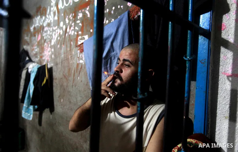 A Palestinian inmate smoke a cigarette inside his cell after breaking his fast during the holy month of Ramadan at prison controlled by the Hamas police in Gaza city on 29 July 2012. Hamas police released more than 150 c...