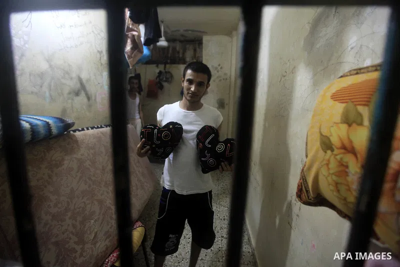 A Palestinian holds wool hearts inside his cell during the holy month of Ramadan at prison controlled by the Hamas police in Gaza city on 29 July 2012. Hamas police released more than 150 criminal inmates before the fast...