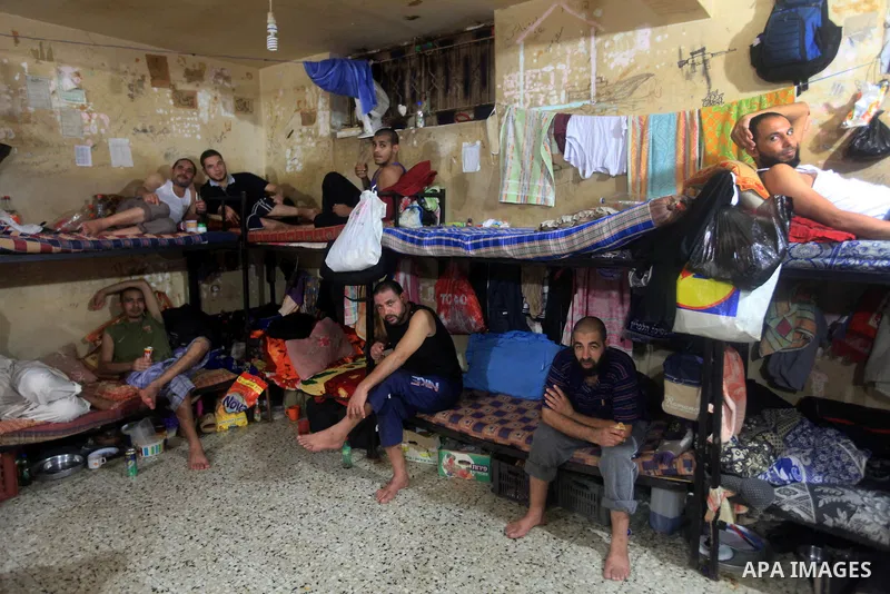 Palestinian inmates sit inside their cell during the holy month of Ramadan at prison controlled by the Hamas police in Gaza city on 29 July 2012. Hamas police released more than 150 criminal inmates before the fasting mo...