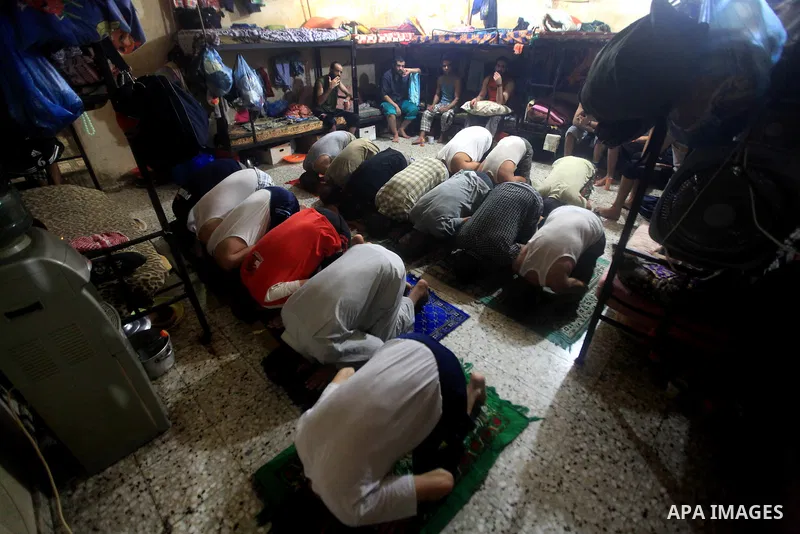 Palestinian inmates participate a prayer during the holy month of Ramadan at prison controlled by the Hamas police in Gaza city on 29 July 2012. Hamas police released more than 150 criminal inmates before the fasting mon...