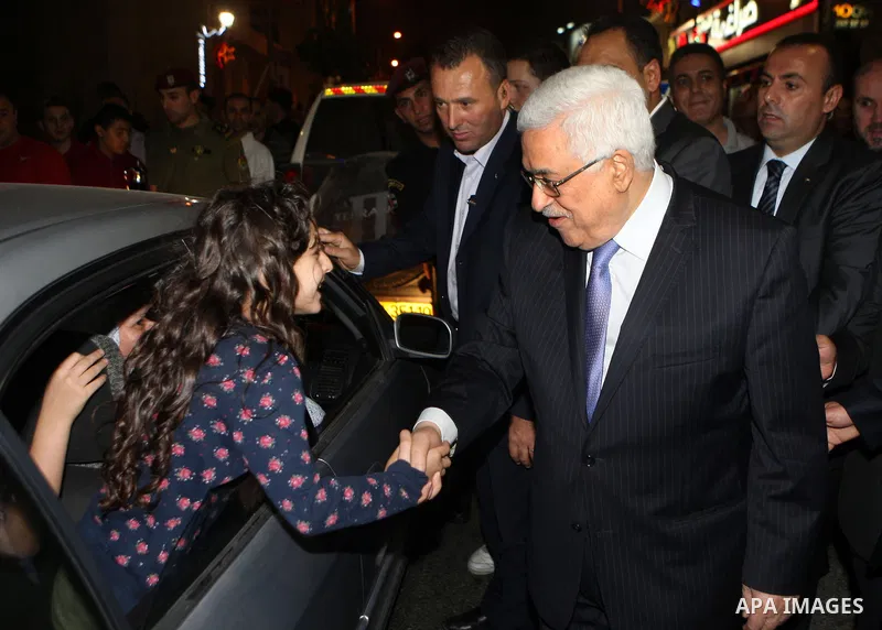 Palestinian President Mahmoud Abbas (abu mazen) shakes hand with a girl during a tour of Ramallah city in the West Bank in the holy month of Ramadan, on 29 July 2012. Photo by Thaer Ganaim