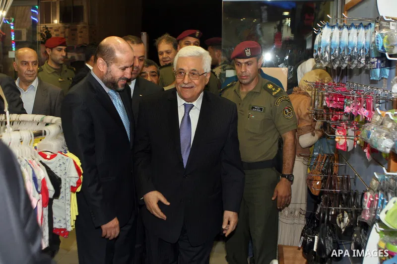 Palestinian President Mahmoud Abbas (abu mazen) enters a shop with the Minister of Religious Affairs mahmoud al-Habbash during a tour of Ramallah city in the West Bank in the holy month of Ramadan, on 29 July 2012. Photo...