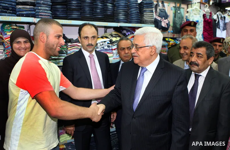 Palestinian President Mahmoud Abbas (abu mazen) shakes hand with a shop owner during a tour of Ramallah city in the West Bank in the holy month of Ramadan, on 29 July 2012. Photo by Thaer Ganaim