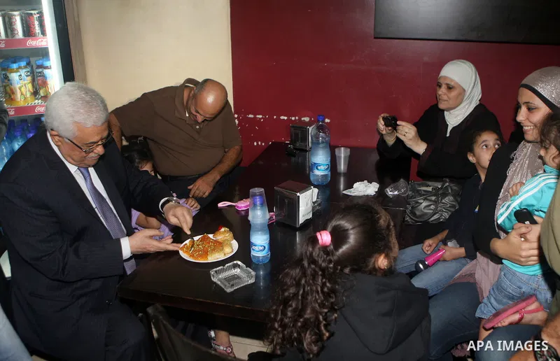 Palestinian President Mahmoud Abbas (abu mazen) participate a Palestinian family in a restaurant during a tour of Ramallah city in the West Bank in the holy month of Ramadan, on 29 July 2012. Photo by Thaer Ganaim