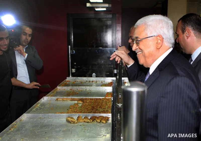 Palestinian President Mahmoud Abbas (abu mazen) enters a shop during a tour of Ramallah city in the West Bank in the holy month of Ramadan, on 29 July 2012. Photo by Thaer Ganaim