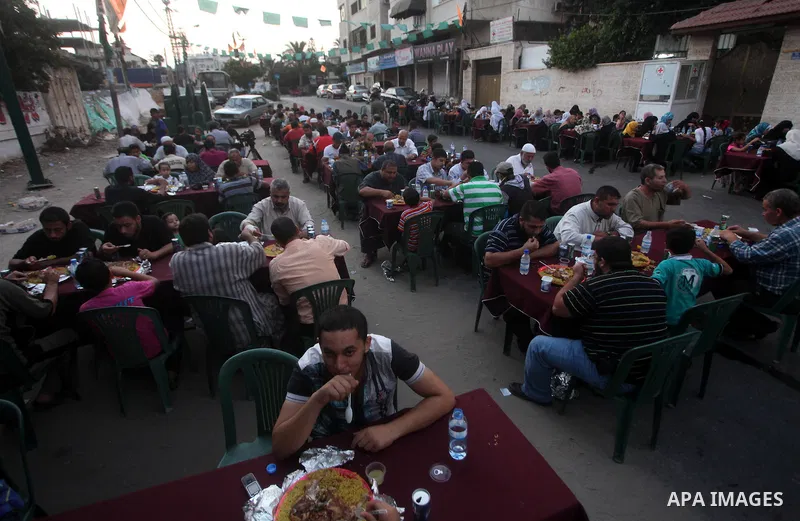 Families of Palestinian prisoners in Israeli jails attend the collective breaking fast organized by the Association of "Wa'ed" and funded by the Turkish relief "IHH" in front of the Red Cross headquarters during the holy...
