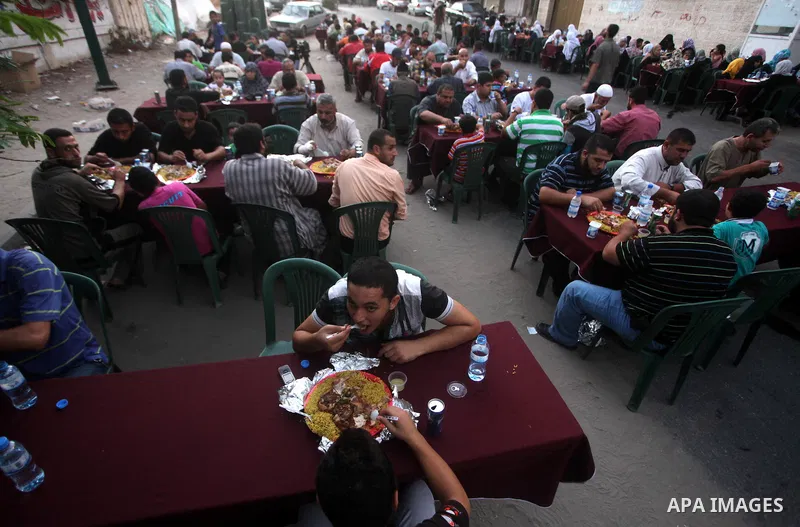 Families of Palestinian prisoners in Israeli jails attend the collective breaking fast organized by the Association of "Wa'ed" and funded by the Turkish relief "IHH" in front of the Red Cross headquarters during the holy...
