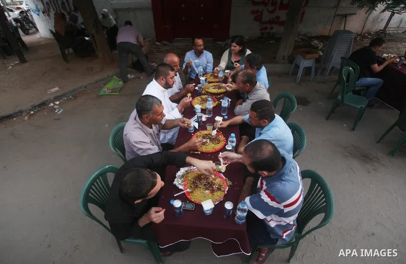 Families of Palestinian prisoners in Israeli jails attend the collective breaking fast organized by the Association of "Wa'ed" and funded by the Turkish relief "IHH" in front of the Red Cross headquarters during the holy...