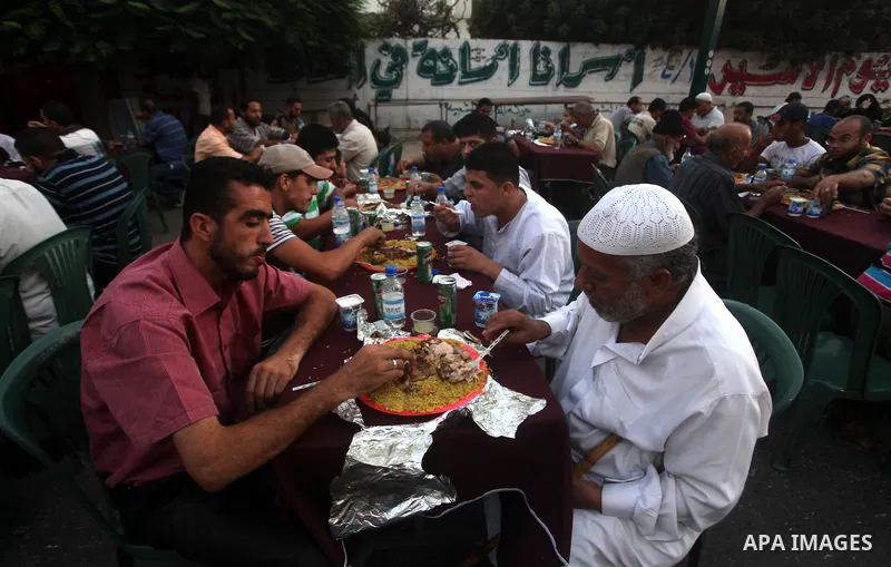 Families of Palestinian prisoners in Israeli jails attend the collective breaking fast organized by the Association of "Wa'ed" and funded by the Turkish relief "IHH" in front of the Red Cross headquarters during the holy...