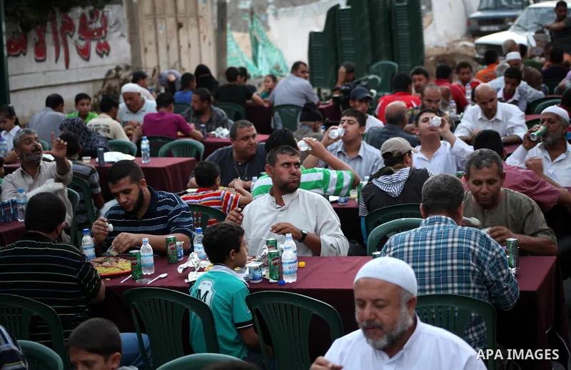 Families of Palestinian prisoners in Israeli jails attend the collective breaking fast organized by the Association of "Wa'ed" and funded by the Turkish relief "IHH" in front of the Red Cross headquarters during the holy...