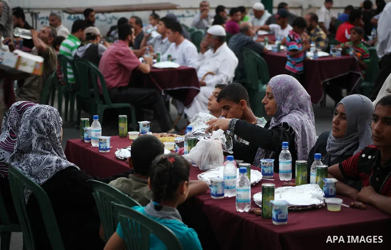 Families of Palestinian prisoners in Israeli jails attend the collective breaking fast organized by the Association of "Wa'ed" and funded by the Turkish relief "IHH" in front of the Red Cross headquarters during the holy...