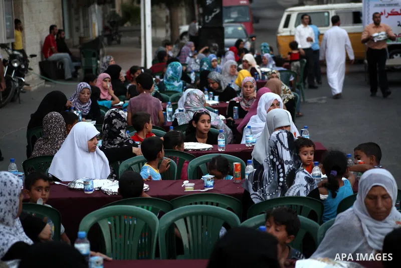 Families of Palestinian prisoners in Israeli jails attend the collective breaking fast organized by the Association of "Wa'ed" and funded by the Turkish relief "IHH" in front of the Red Cross headquarters during the holy...