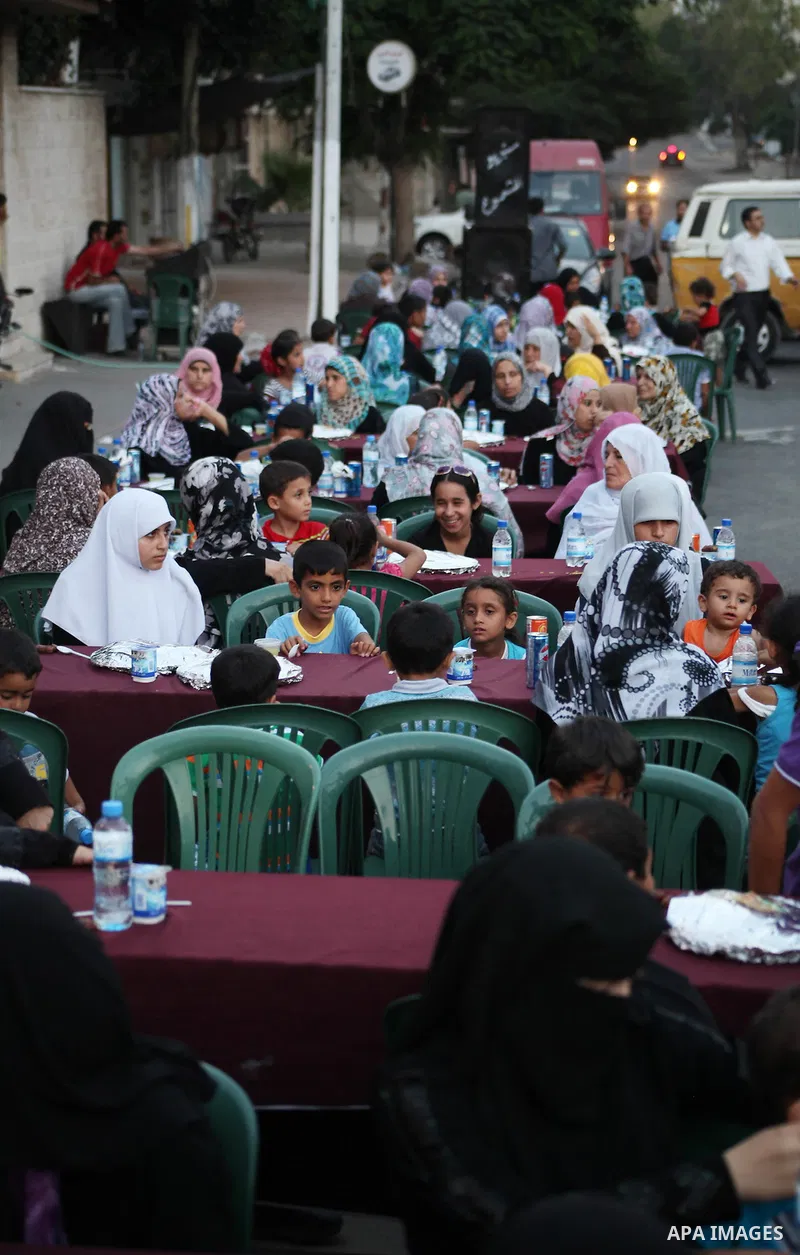 Families of Palestinian prisoners in Israeli jails attend the collective breaking fast organized by the Association of "Wa'ed" and funded by the Turkish relief "IHH" in front of the Red Cross headquarters during the holy...