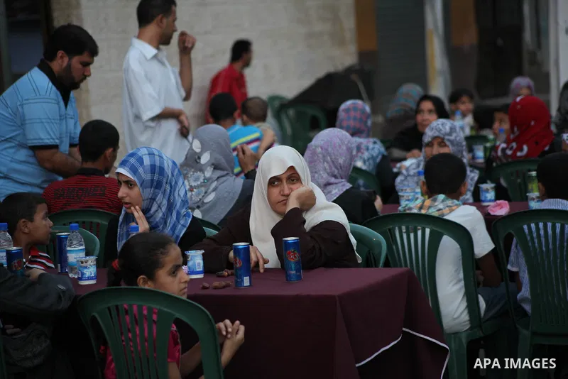 Families of Palestinian prisoners in Israeli jails attend the collective breaking fast organized by the Association of "Wa'ed" and funded by the Turkish relief "IHH" in front of the Red Cross headquarters during the holy...