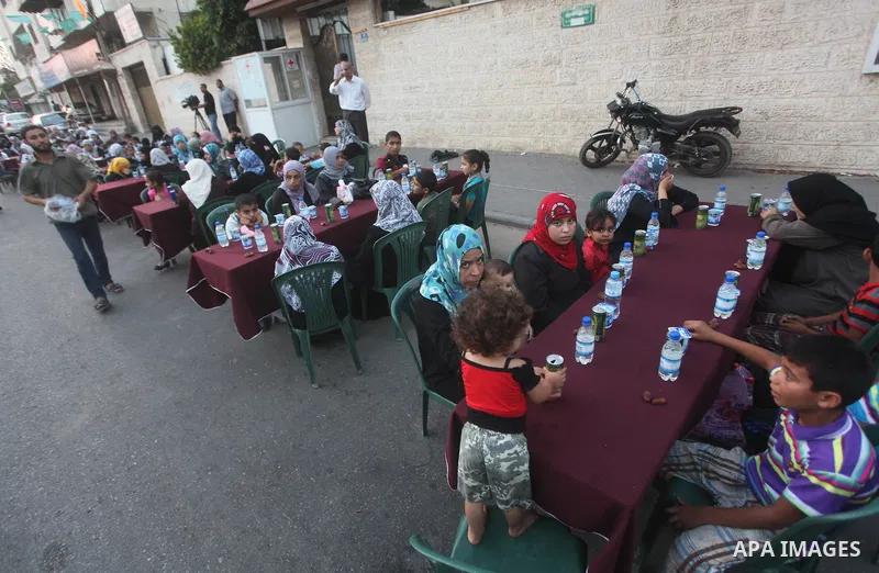 Families of Palestinian prisoners in Israeli jails attend the collective breaking fast organized by the Association of "Wa'ed" and funded by the Turkish relief "IHH" in front of the Red Cross headquarters during the holy...