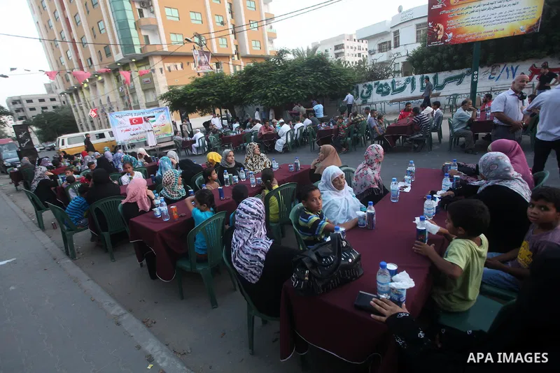Families of Palestinian prisoners in Israeli jails attend the collective breaking fast organized by the Association of "Wa'ed" and funded by the Turkish relief "IHH" in front of the Red Cross headquarters during the holy...
