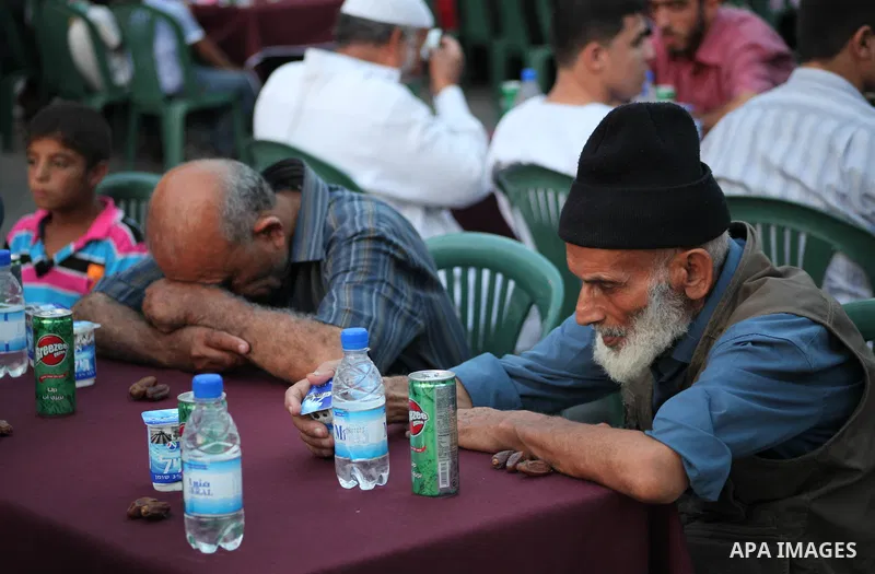 Families of Palestinian prisoners in Israeli jails attend the collective breaking fast organized by the Association of "Wa'ed" and funded by the Turkish relief "IHH" in front of the Red Cross headquarters during the holy...