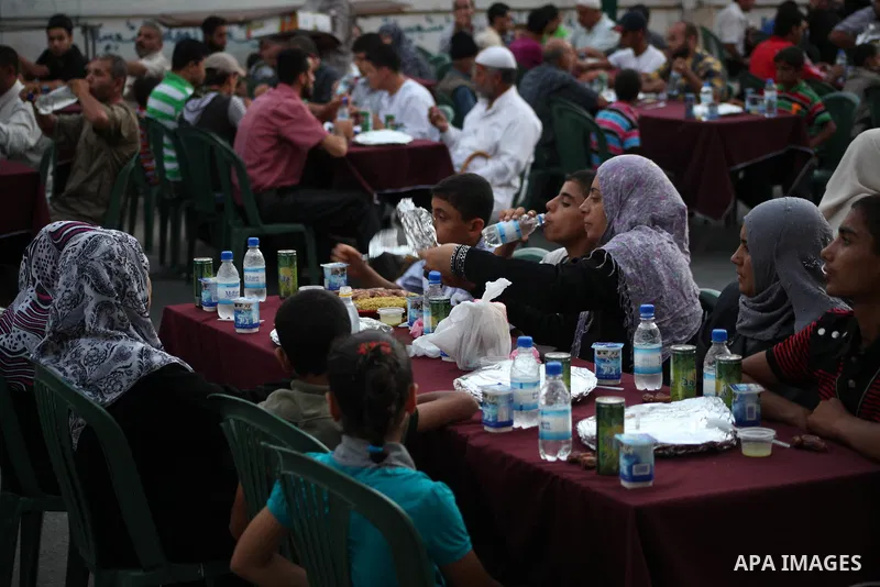 Families of Palestinian prisoners in Israeli jails attend the collective breaking fast organized by the Association of "Wa'ed" and funded by the Turkish relief "IHH" in front of the Red Cross headquarters during the holy...