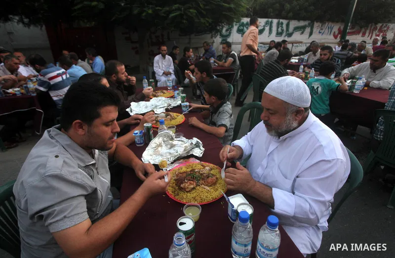 Families of Palestinian prisoners in Israeli jails attend the collective breaking fast organized by the Association of "Wa'ed" and funded by the Turkish relief "IHH" in front of the Red Cross headquarters during the holy...